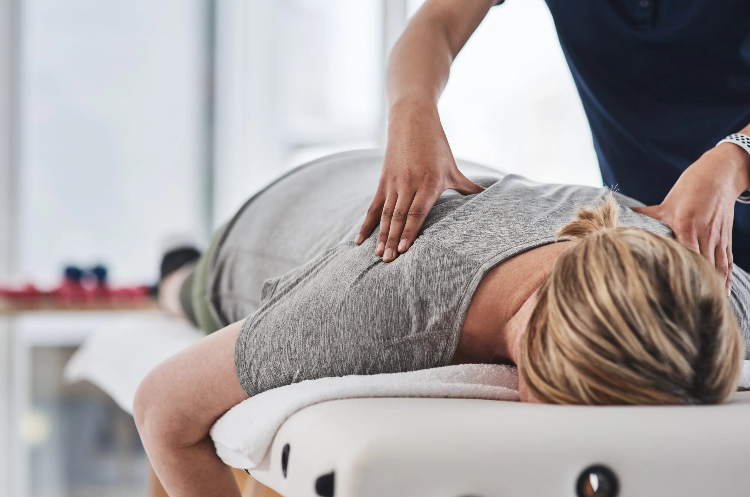 Massage therapist presses along a client’s back during a session.
