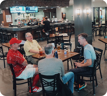 Group of men sitting at a table in the Courtside Grill enjoying each other's company