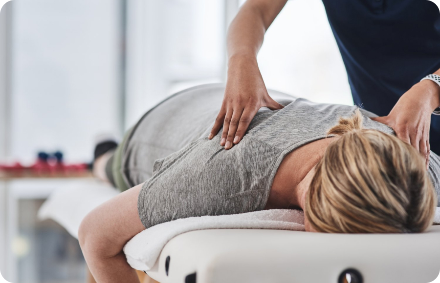Massage therapist presses along a client’s back during a session.