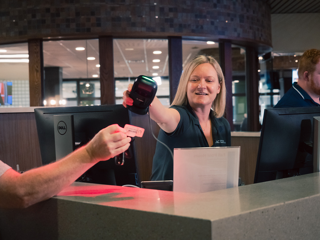 Receptionist scanning member ID to enter MAC