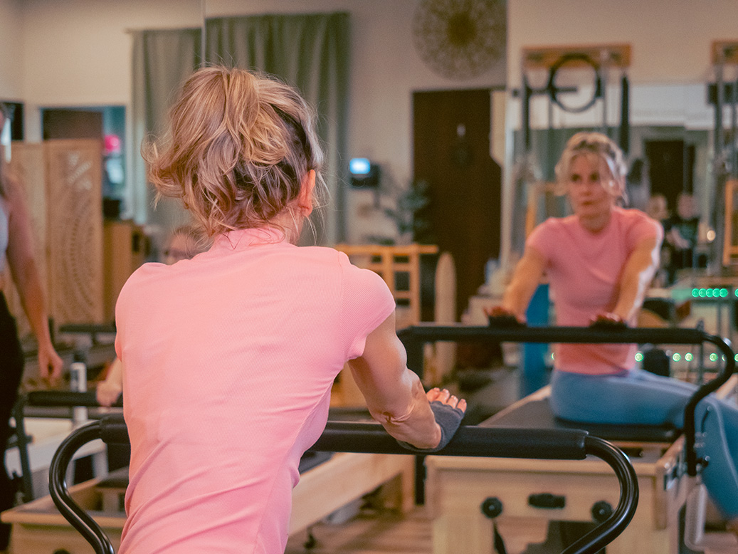 Woman working out and stretching on pilates equipment