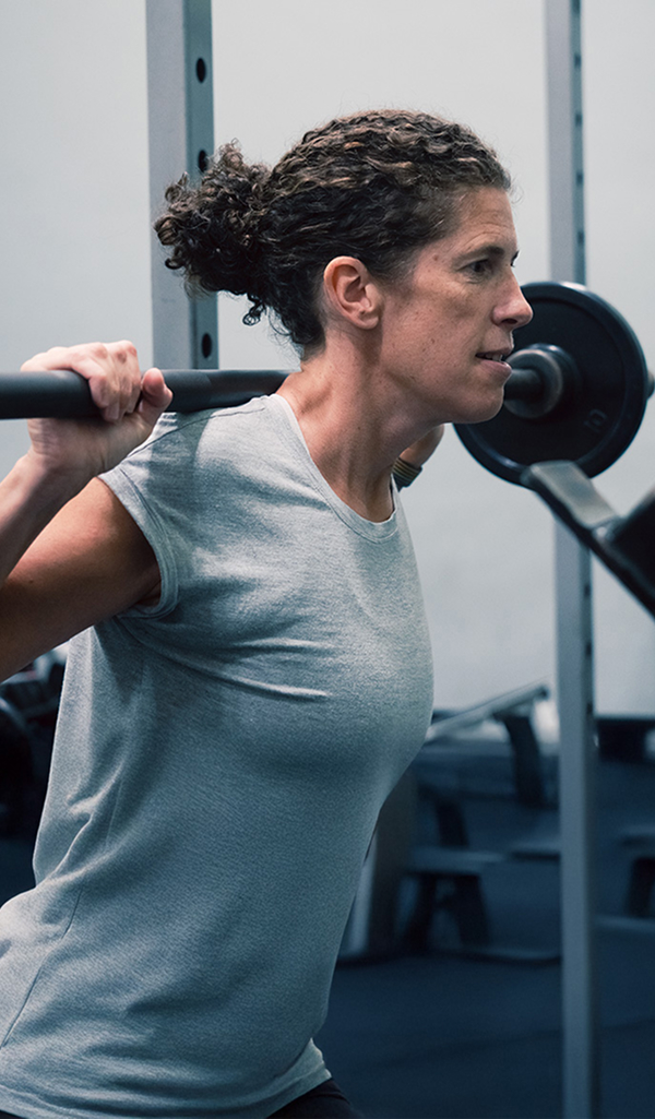 Weightlifter working out with barbell in fitness center